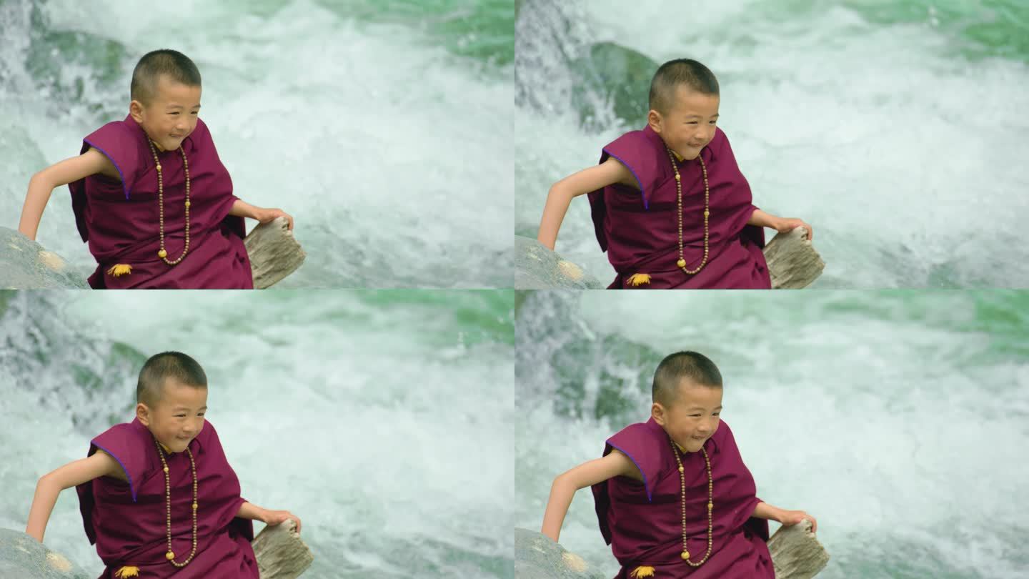 小喇嘛坐在流水旁的石头上状态