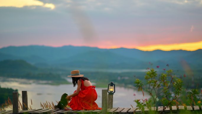 风景山侧姑娘背影红裙草帽度假旅游