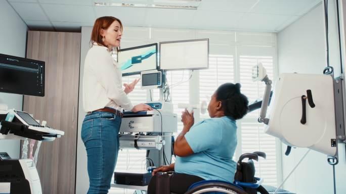残疾妇女在开始健身之旅之前，在一家现代化的健康中心接受肺功能测试。医生对患有哮喘的截瘫或身体受损女性