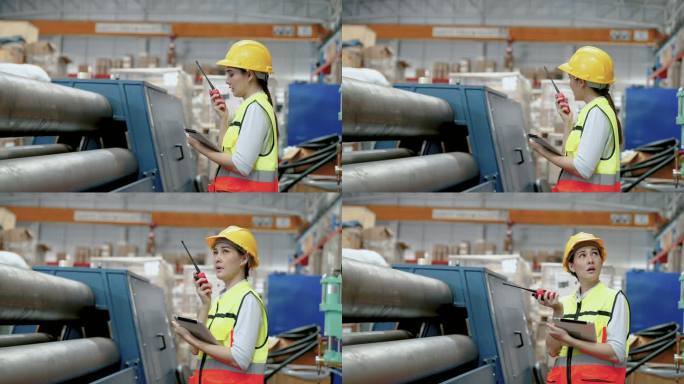 年轻的亚洲仓库检查员使用无线电向另一名员工报告机器状态。