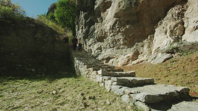 藏族情侣牵手从石阶上跑下