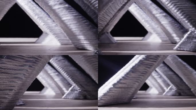 室内制造设施中一系列3D打印的三角形铝制物体的缓慢拉出镜头
