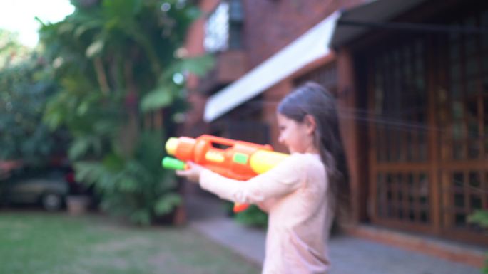 父亲和女儿在后院玩喷枪