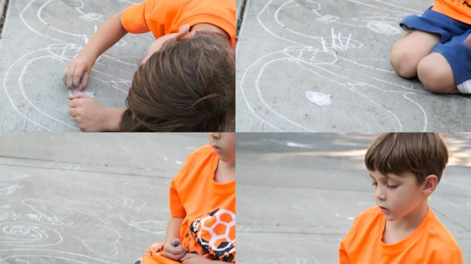 小男孩用粉笔画地板