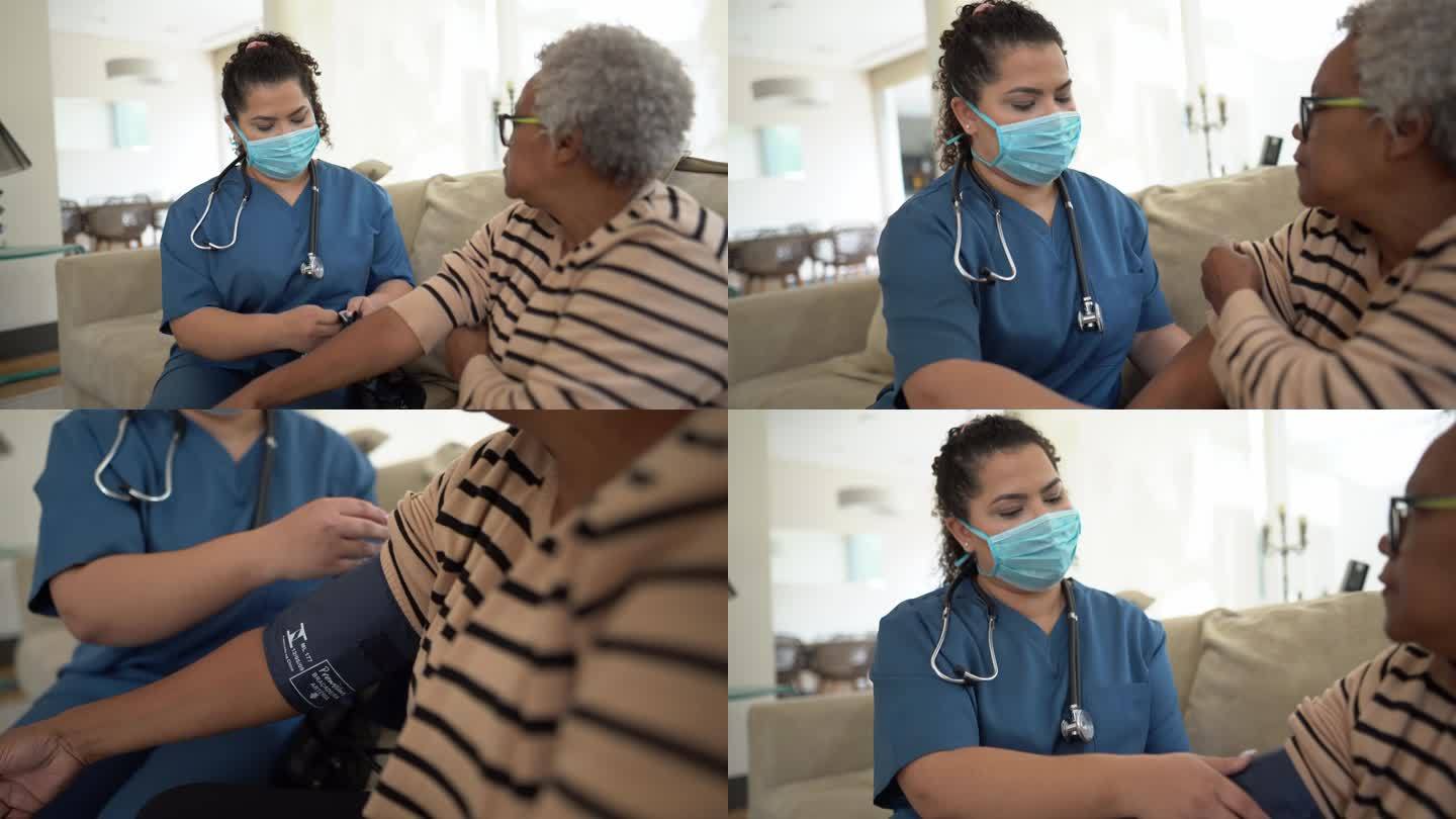 护士在家访期间测量老年患者的血压-佩戴防护面罩