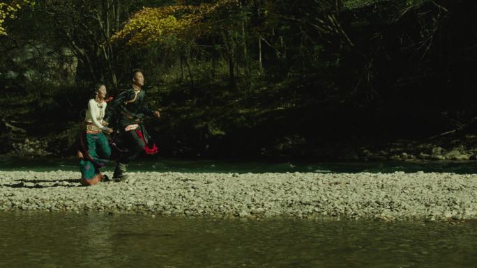 藏族情侣牵手河边奔跑