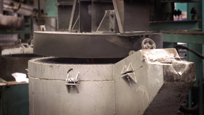 铝熔化，操作员努力将熔融金属从钢包中取出至保温炉压铸机