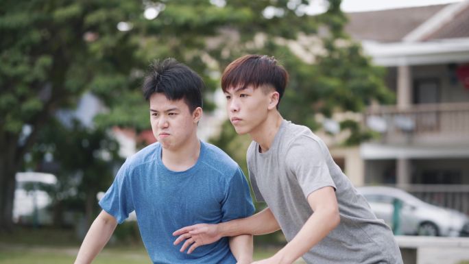 Z世代亚洲华裔少年周末与朋友在篮球比赛中阻挡对手球员