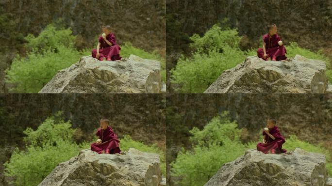 小喇嘛坐在石块上吃馒头