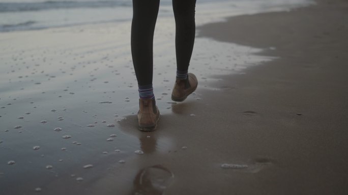 年轻女子在冬季探索海滩