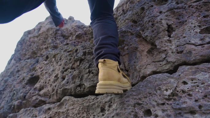 登山脚步特写爬上山顶户外探险攀岩运动鞋