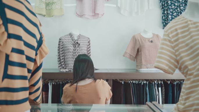 亚洲女人在购物中心挑选衣服