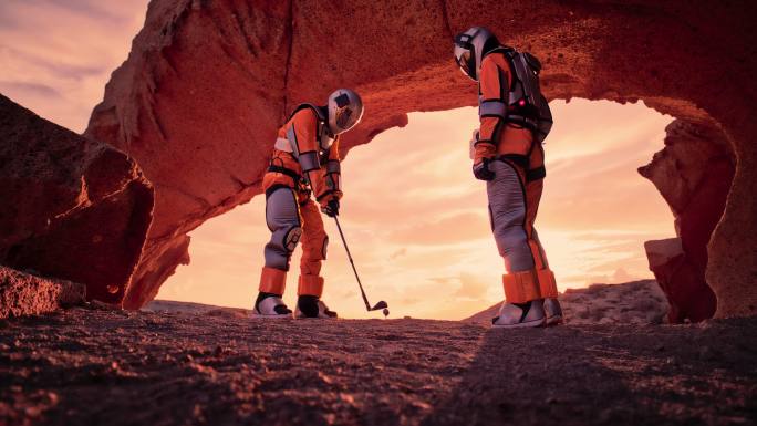 红色星球火星上的两名宇航员。在外星星球上打高尔夫球