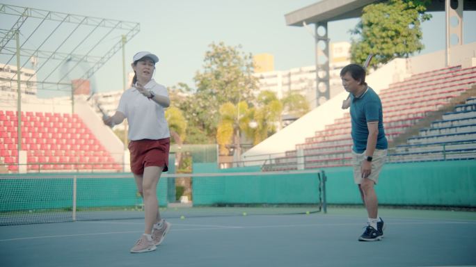 一群健康的老年人一起享受网球比赛。