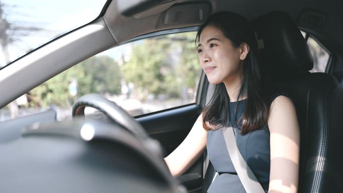 亚洲泰国/中国女商人用耳机和汽车谈生意