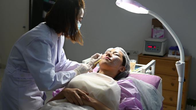 在PRP吸血鬼整容手术中，亚裔中国美容学家为患者注射血浆。