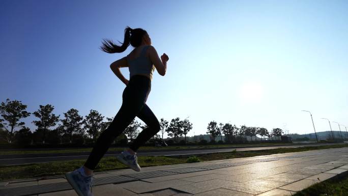 清晨女孩跑步女孩公路上奔跑运动锻炼户外光