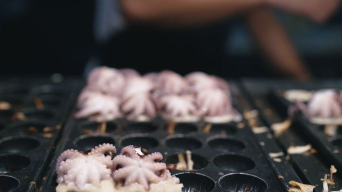 亚洲市场供应商为客户准备Takoyaki。