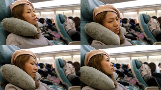 4K镜头：一名亚洲女子在飞机上睡着了。长途作战感到厌倦