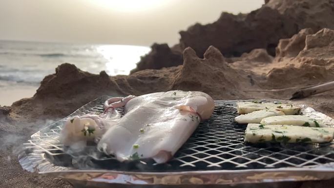 无法辨认的游客在岸上烧烤。菜单上有鱿鱼和章鱼。