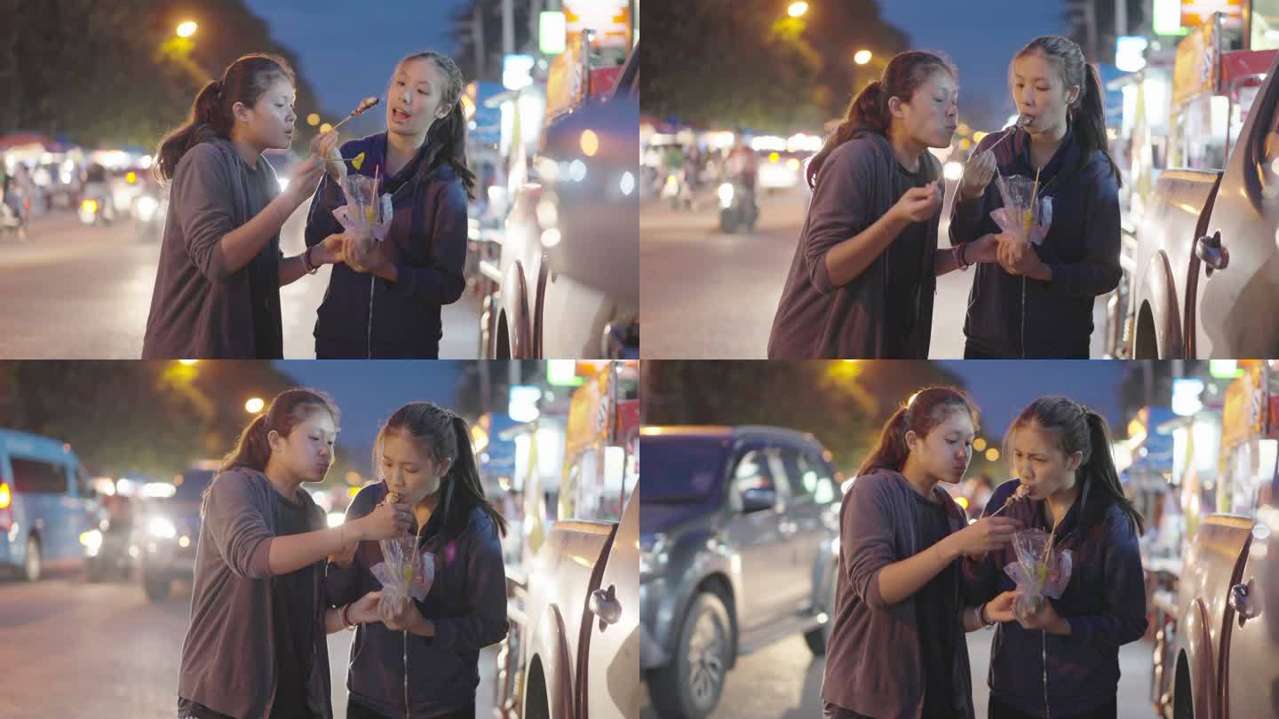 斯洛莫-亚洲朋友喜欢在夜市上吃烤鱿鱼。泰国街头美食。