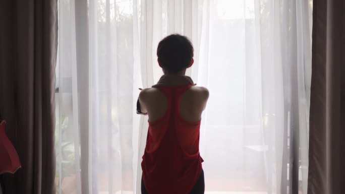 慢动作亚裔中国中年女性手臂伸开窗帘走到后院锻炼