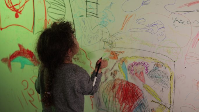 小卷发女孩在房间的墙上作画，墙壁绘画，墙壁艺术，自由女孩，成为艺术家，小女孩绘画