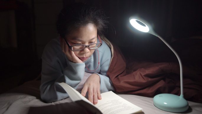 亚洲女人晚上在床上看书