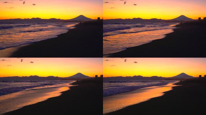 日落时的富士山和沙滩。小鸟从海浪中逃跑