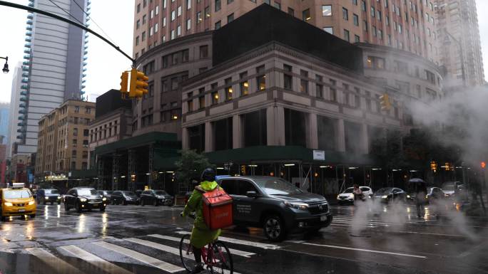 白天多雨的纽约人流穿行车流路口商业繁华