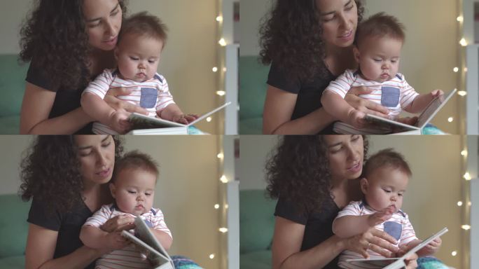 年轻慈爱的母亲在睡前给可爱的宝宝读故事书