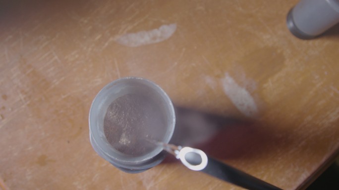 手持式镜头：热水从水壶倒入咖啡冲泡机中，形成“花开”并使相机镜头起雾