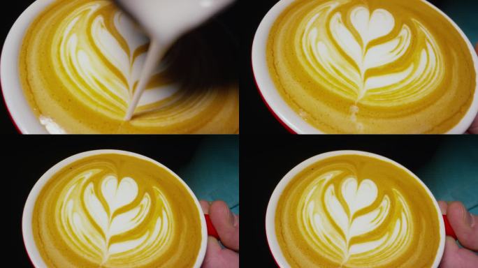 一名咖啡师在咖啡店将蒸牛奶倒入浓缩咖啡杯时制作拿铁咖啡艺术的特写镜头