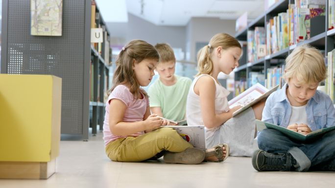 DS儿童在公共图书馆地板上看书