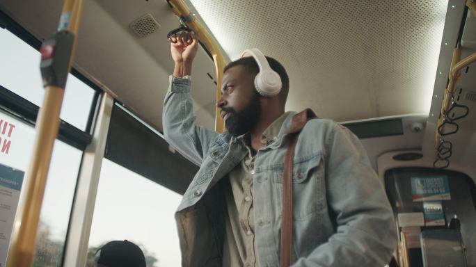 一名年轻男子在公交车上使用耳机的4k视频片段