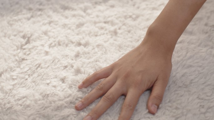 手摸柔软地毯的特写镜头，蓬松柔软舒适。