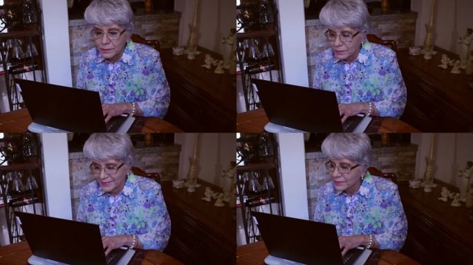 一位拉丁美洲高级女士坐在餐桌旁，在家里用笔记本电脑工作