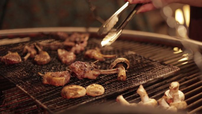 在烧烤或烧烤上烹饪蘑菇和肉，将肉转为烧烤，在火上烹饪蘑菇，在烧烤火上烹饪香菇和肉，把肉和香菇转为在烧