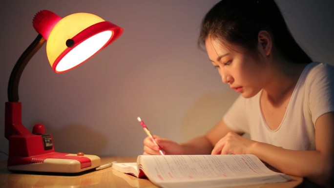 夜晚台灯下刻苦学习的女大学生