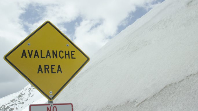 “雪崩地区”警告路标位于科罗拉多州落基山脉，冬季天空覆盖