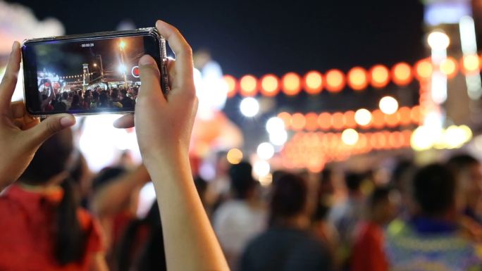 中国春节期间，游客夜间在城市拍照