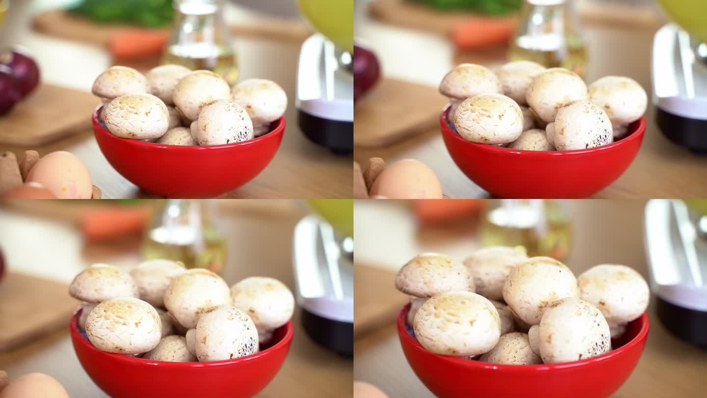 木制餐桌上碗里的新鲜蘑菇