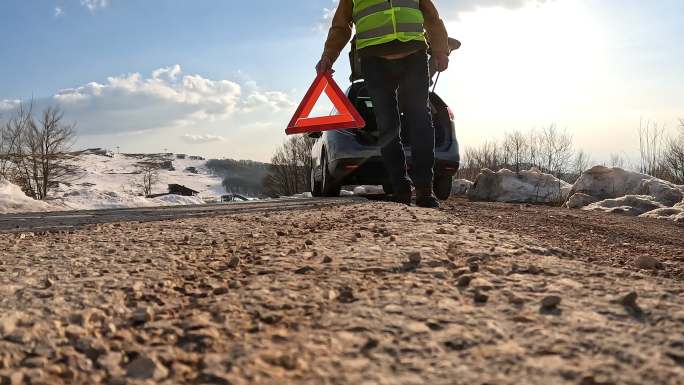 高级男子在道路上放置三角警示牌