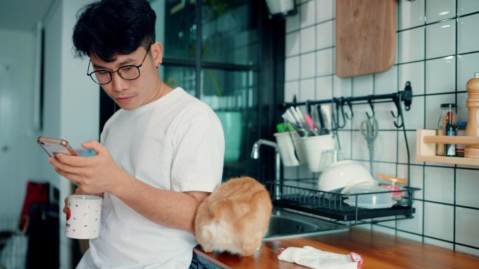 早上，男人带着小狗在厨房放松。
