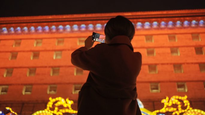中国春节期间使用智能手机与城市景观的女人之手