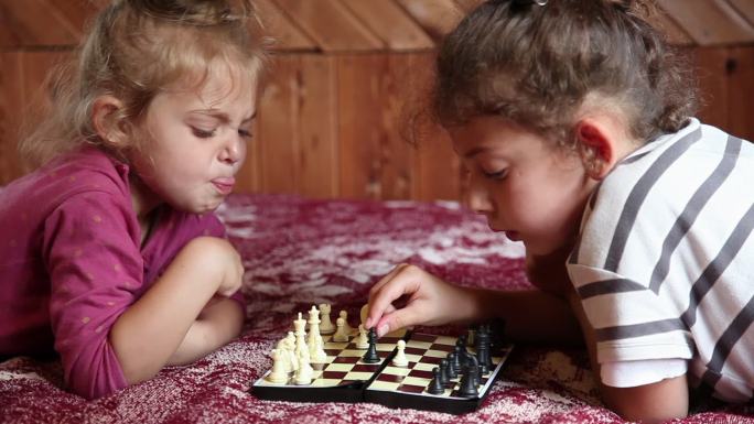 小女孩和妹妹在床上下棋时抠鼻子