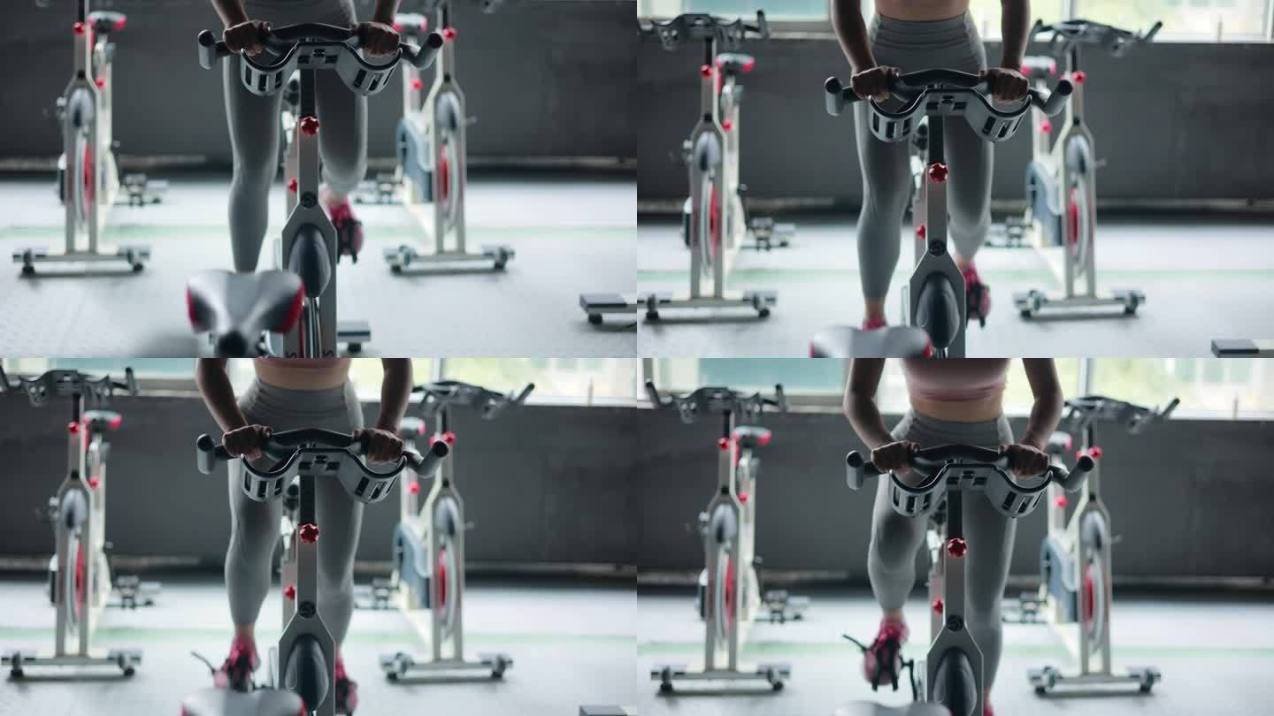 妇女在健身房骑自行车锻炼