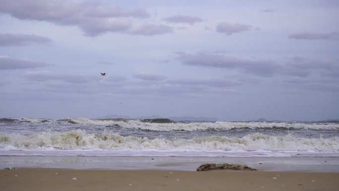 阴天海浪翻滚冲上沙滩