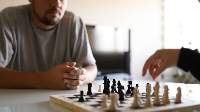 爸爸在看女儿下棋中年男子下国际象棋跳棋棋