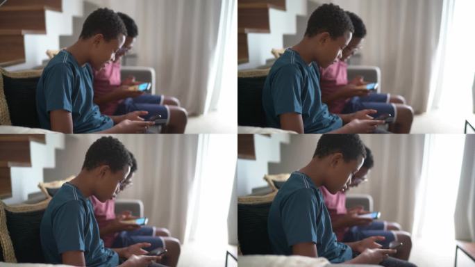 一对双胞胎兄弟在客厅里用智能手机玩游戏
